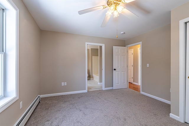 unfurnished bedroom featuring a ceiling fan, a baseboard heating unit, ensuite bath, carpet flooring, and baseboards