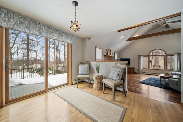 sitting room with a ceiling fan, vaulted ceiling with beams, wood finished floors, and a baseboard radiator