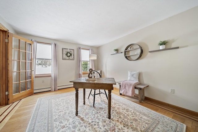 office with baseboards, light wood-style floors, and a baseboard radiator