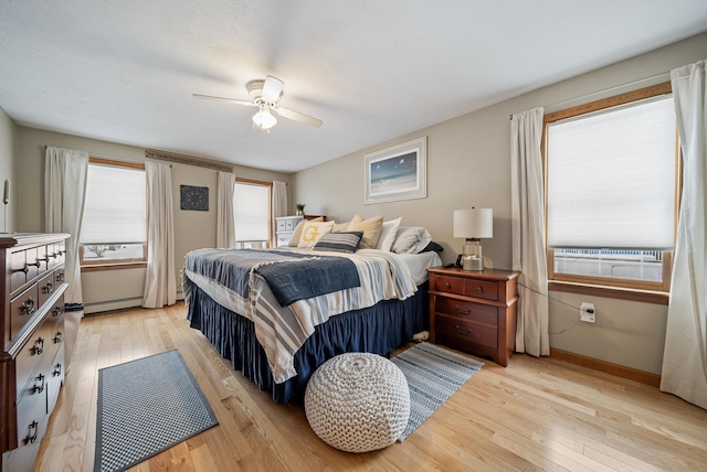 bedroom featuring light wood-style flooring, a ceiling fan, baseboards, and baseboard heating