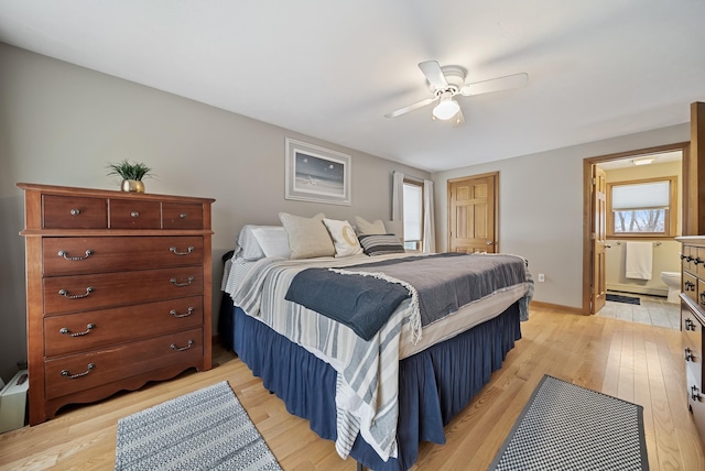 bedroom with baseboards, light wood-style floors, ensuite bathroom, and a ceiling fan