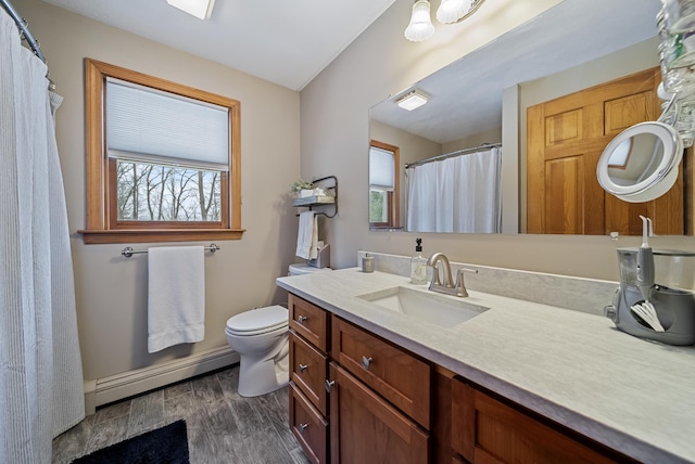 full bathroom with a baseboard heating unit, toilet, wood finished floors, and vanity