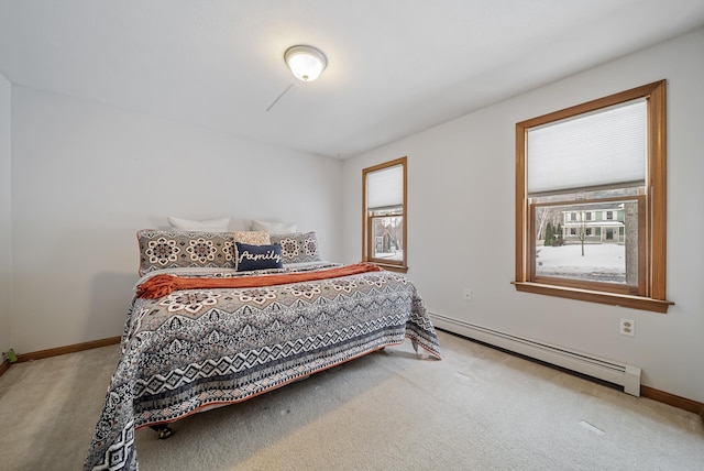 carpeted bedroom with a baseboard heating unit and baseboards