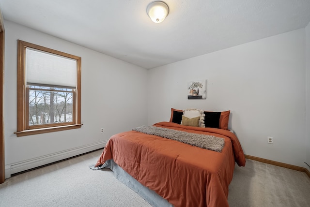 carpeted bedroom featuring baseboard heating and baseboards