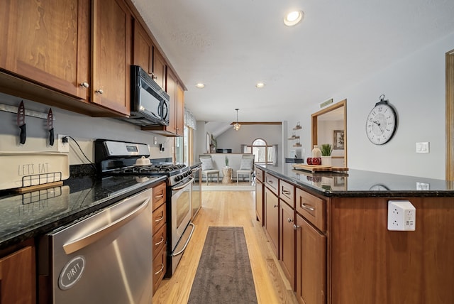 kitchen featuring dark stone countertops, brown cabinets, recessed lighting, stainless steel appliances, and light wood-type flooring