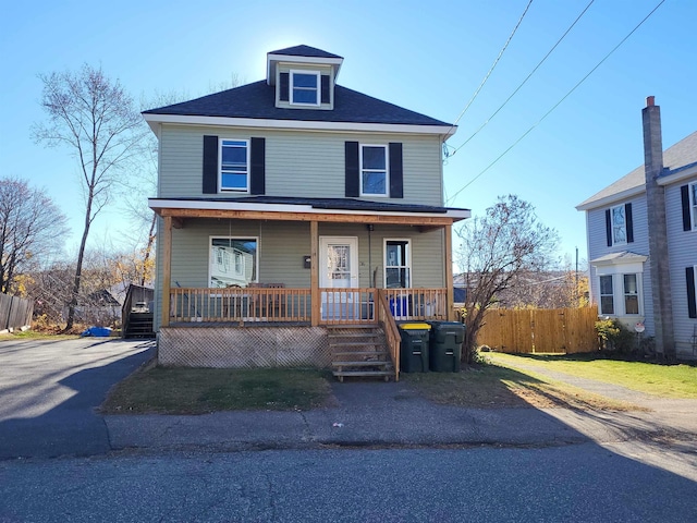 american foursquare style home with fence and covered porch