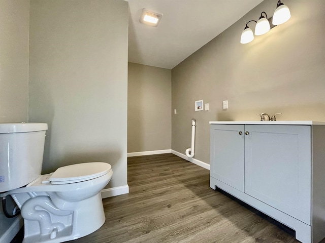 bathroom with baseboards, toilet, and wood finished floors