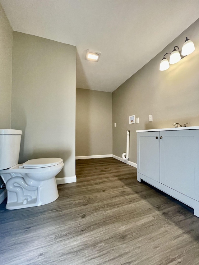 bathroom featuring toilet, wood finished floors, and baseboards