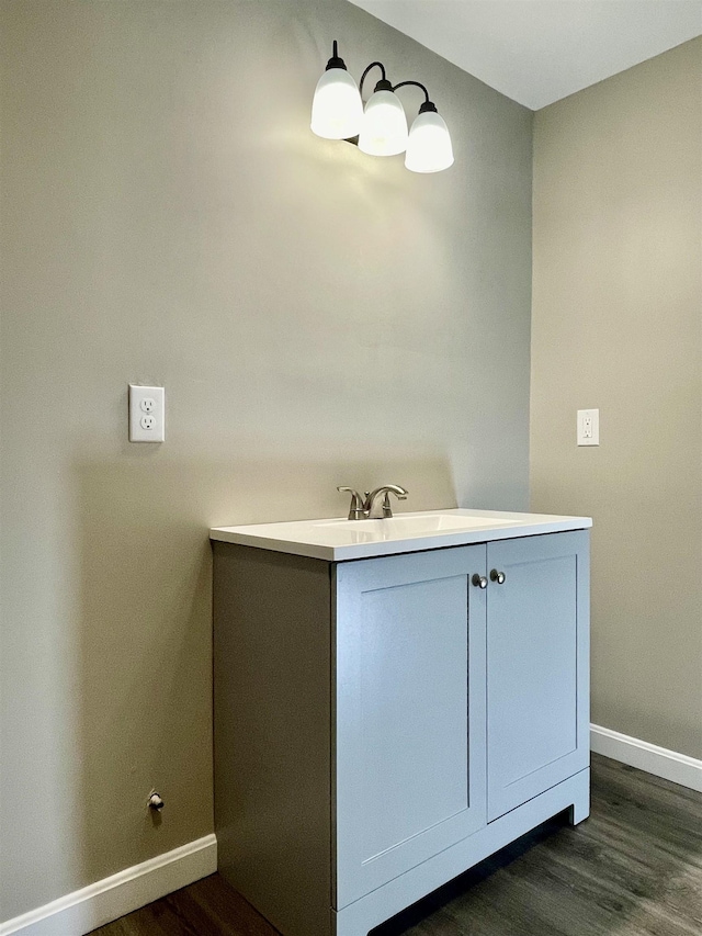 bathroom with a sink, baseboards, and wood finished floors