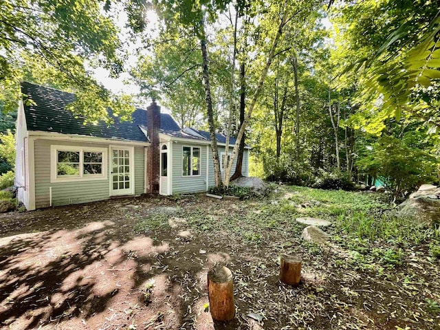 rear view of house featuring a chimney