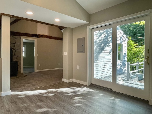 empty room with lofted ceiling, electric panel, wood finished floors, recessed lighting, and baseboards