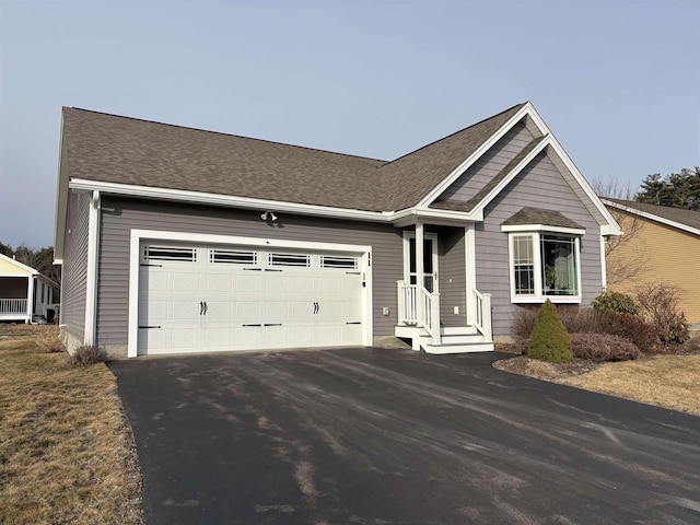 single story home featuring aphalt driveway, an attached garage, and roof with shingles