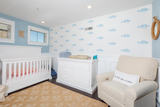 bedroom with wallpapered walls, recessed lighting, dark wood finished floors, and wainscoting