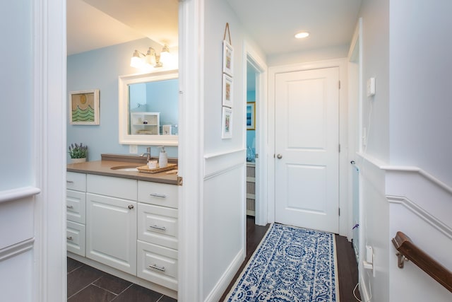 hall with recessed lighting and a sink