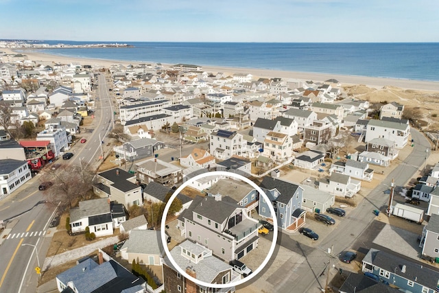 drone / aerial view featuring a beach view, a residential view, and a water view