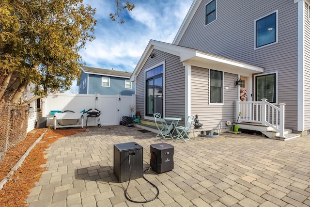 rear view of property with a patio and a fenced backyard