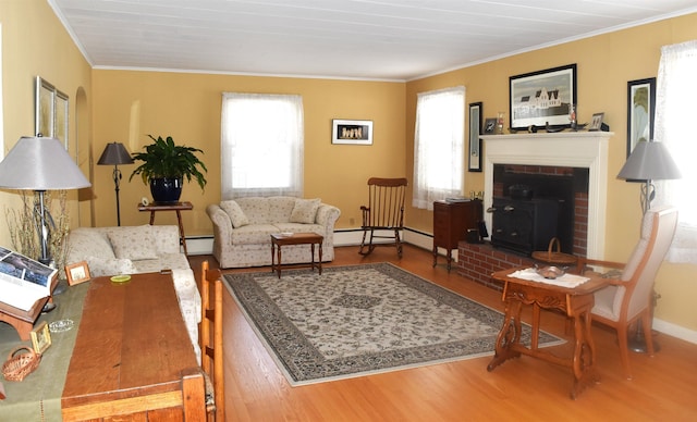 living area featuring wood finished floors, a fireplace, crown molding, baseboards, and baseboard heating