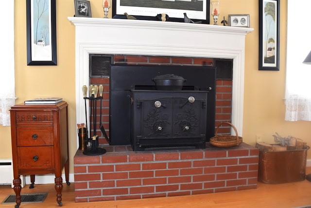 details with visible vents, a fireplace, and wood finished floors