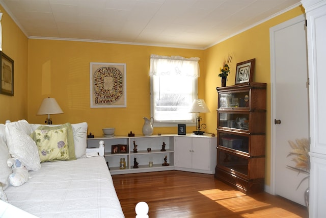 bedroom featuring wood finished floors and ornamental molding