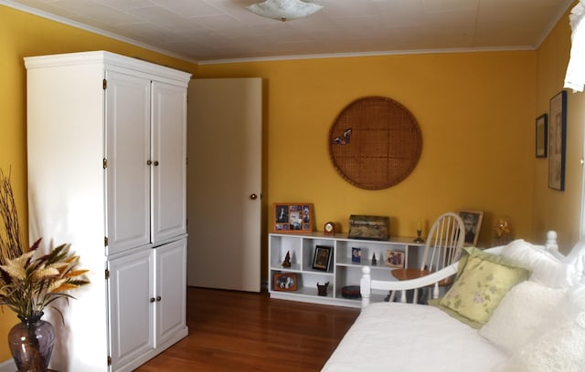 bedroom featuring ornamental molding and wood finished floors