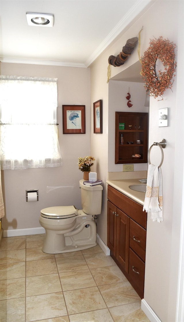 bathroom with vanity, baseboards, tile patterned flooring, crown molding, and toilet