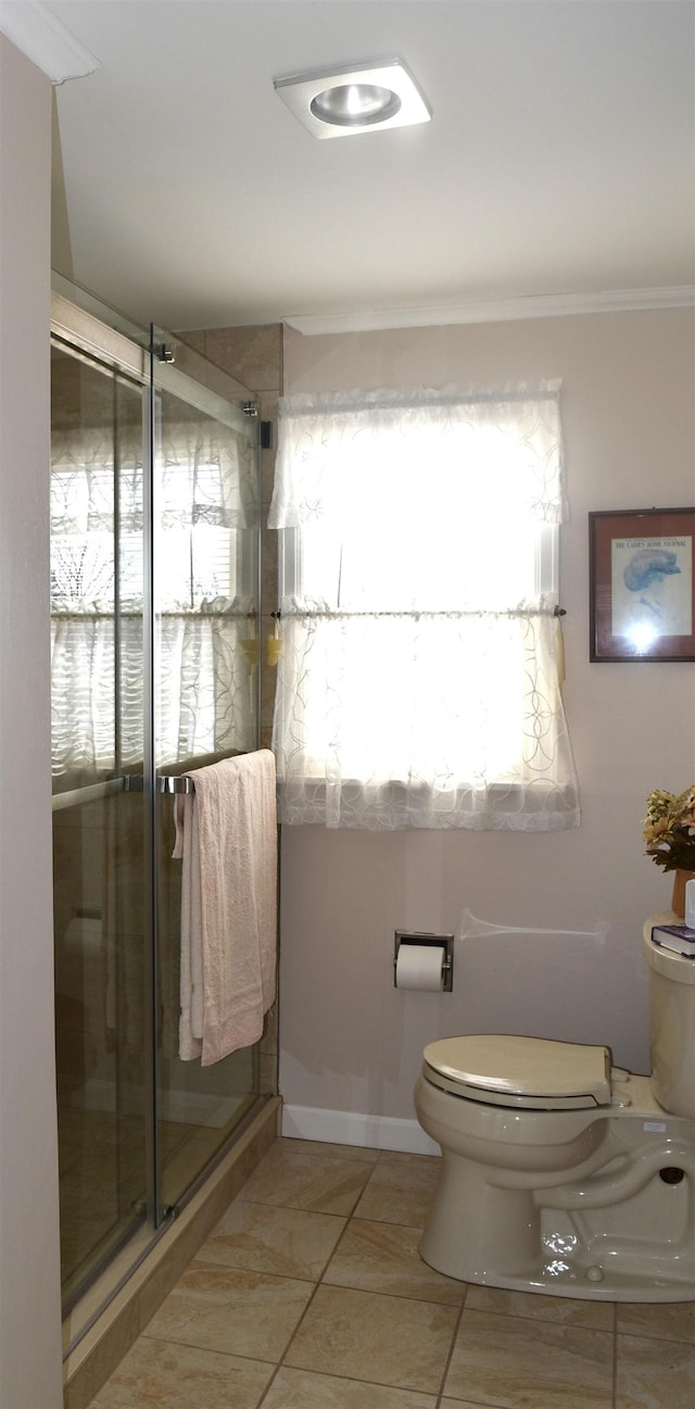 full bathroom featuring tile patterned flooring, a shower stall, toilet, and ornamental molding