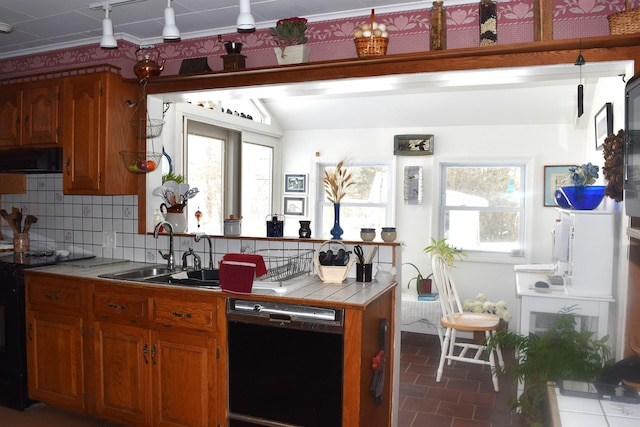 kitchen featuring a sink, black appliances, tile counters, and brown cabinetry