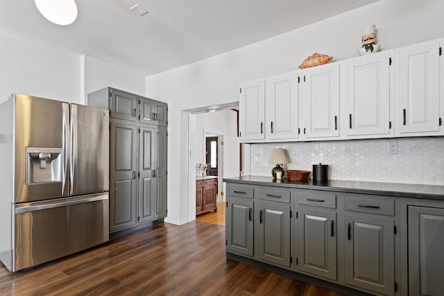 kitchen featuring dark countertops, stainless steel refrigerator with ice dispenser, dark wood-type flooring, and gray cabinetry