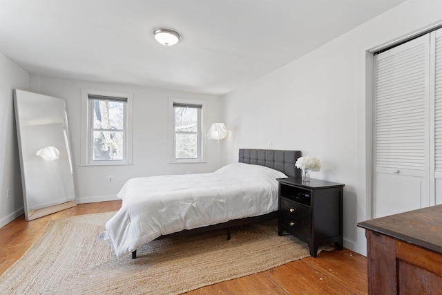 bedroom with light wood-style flooring and baseboards