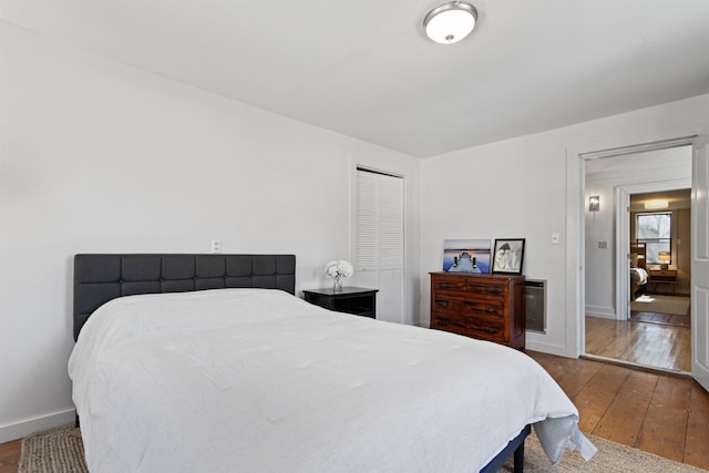 bedroom with a closet, baseboards, and hardwood / wood-style flooring