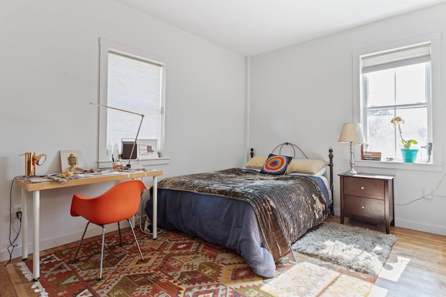 bedroom with baseboards and wood finished floors