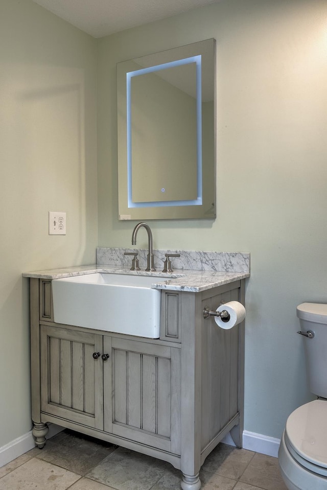 bathroom featuring tile patterned floors, toilet, vanity, and baseboards