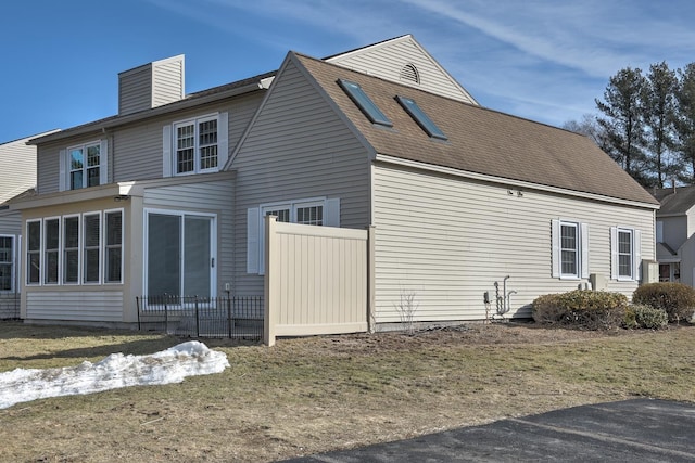 back of house featuring a chimney