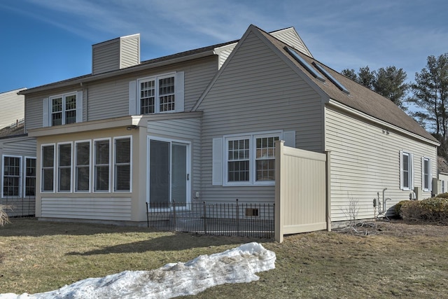 rear view of house with crawl space, a lawn, and a chimney