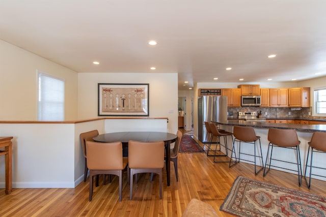 dining room featuring recessed lighting, light wood-type flooring, and baseboards