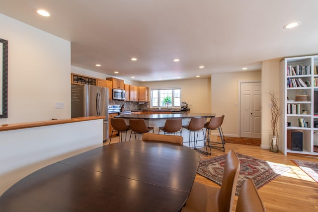 dining area featuring recessed lighting, light wood-style flooring, and baseboards