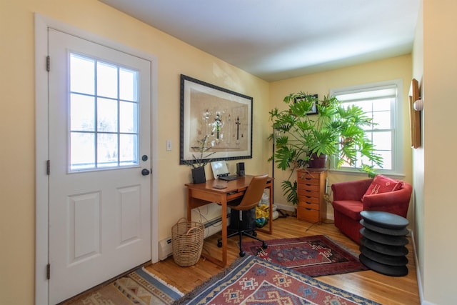 home office with wood finished floors and baseboard heating