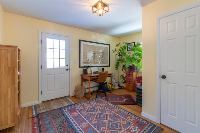 office with baseboard heating, baseboards, and wood finished floors