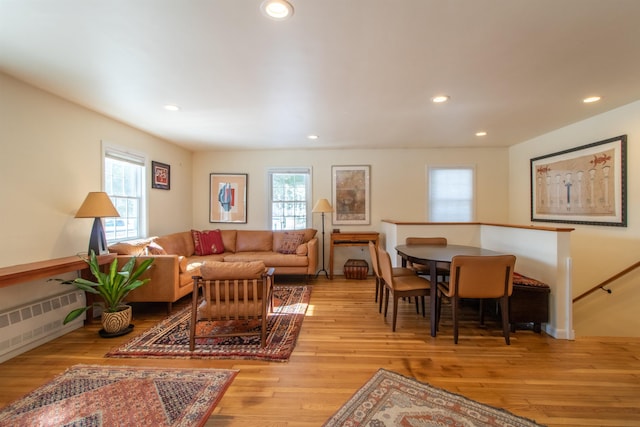 living room with a wealth of natural light, radiator heating unit, and wood finished floors