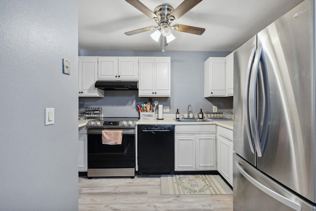 kitchen with a sink, light countertops, under cabinet range hood, appliances with stainless steel finishes, and white cabinetry