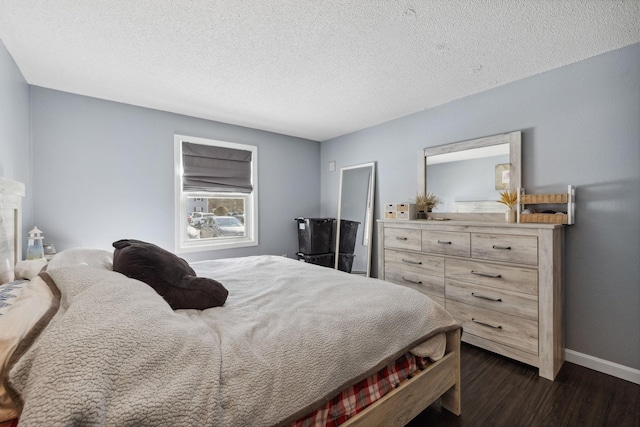 bedroom with dark wood finished floors, baseboards, and a textured ceiling