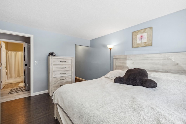 bedroom featuring dark wood-style floors and baseboards