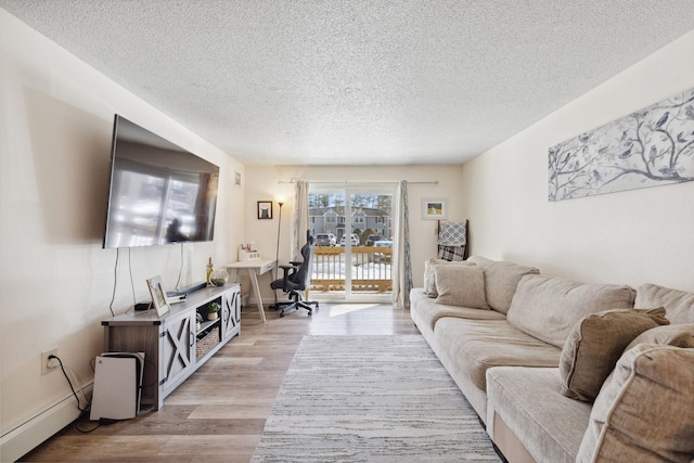 living room with light wood-style flooring, baseboards, baseboard heating, and a textured ceiling