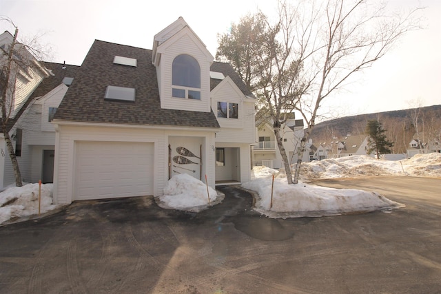 view of front of home featuring roof with shingles and driveway