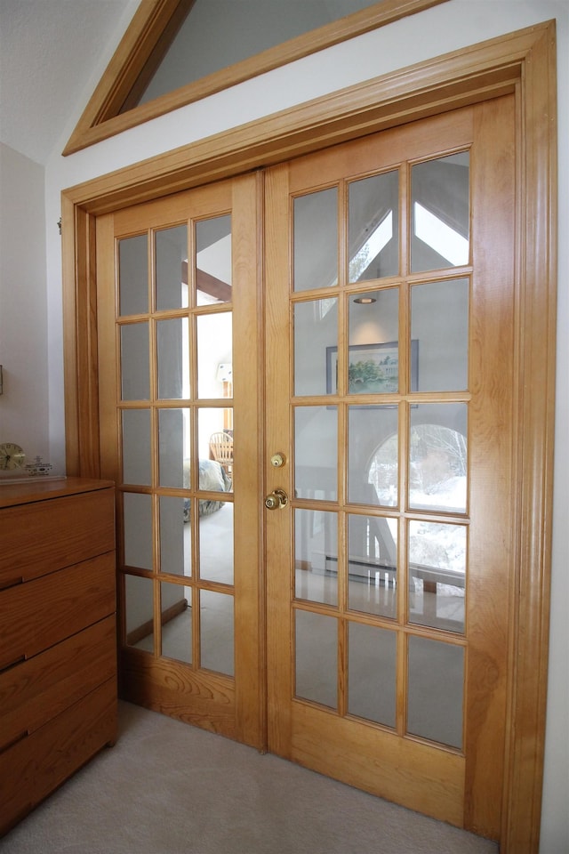 entryway featuring carpet floors, french doors, and vaulted ceiling