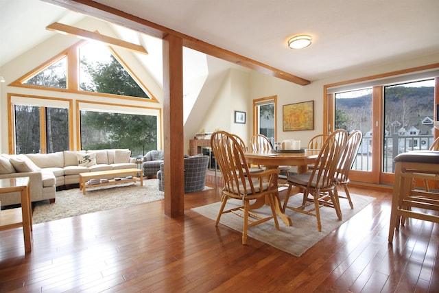 dining room with vaulted ceiling with beams and hardwood / wood-style flooring