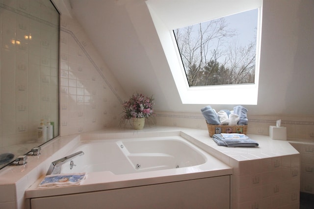 bathroom with a whirlpool tub and vaulted ceiling