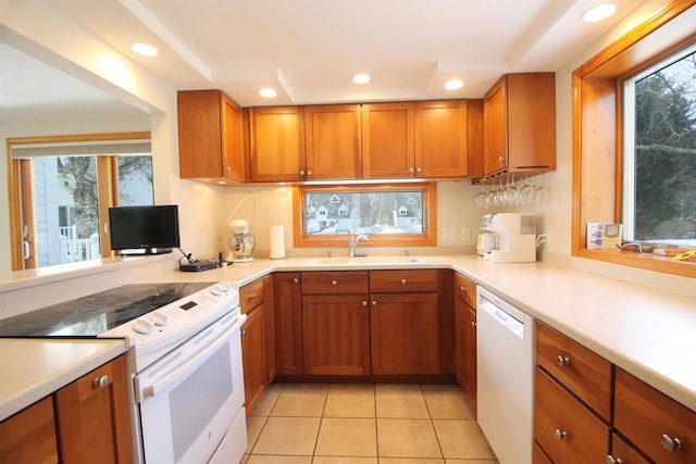 kitchen featuring white appliances, brown cabinetry, and light countertops