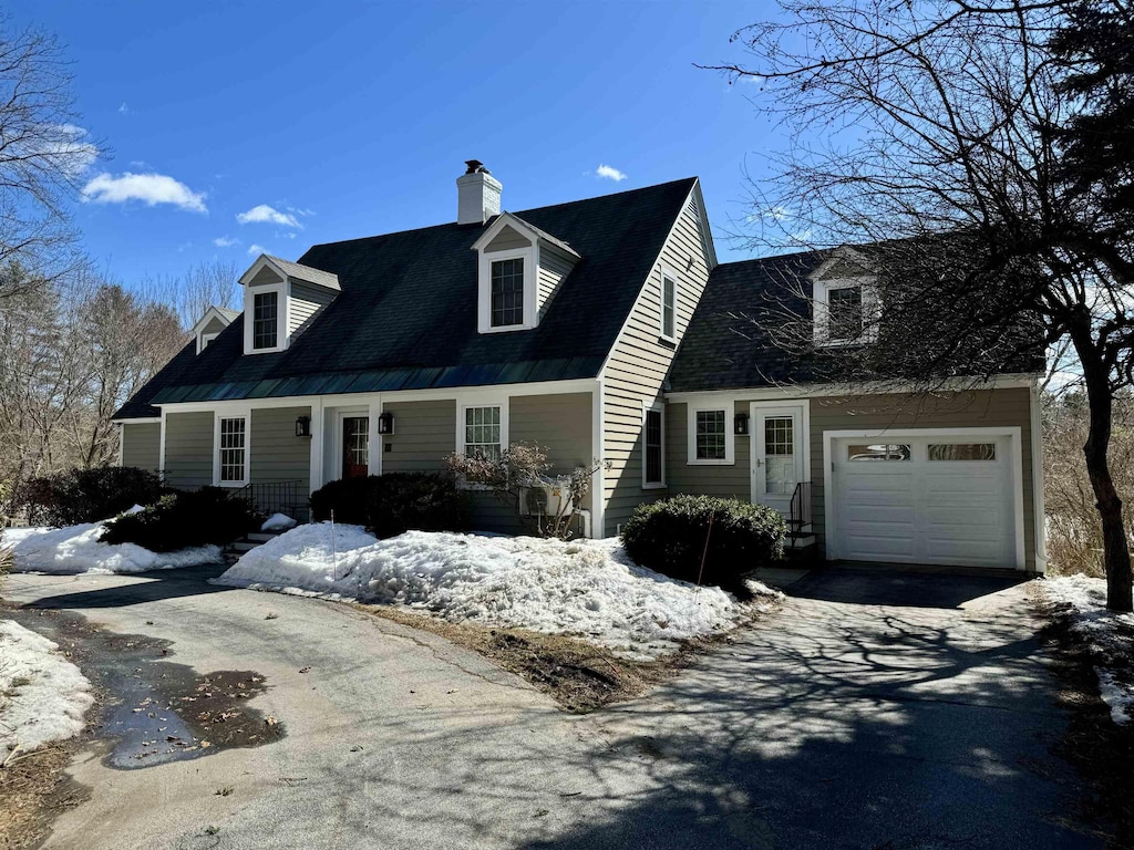 cape cod house with aphalt driveway and a chimney
