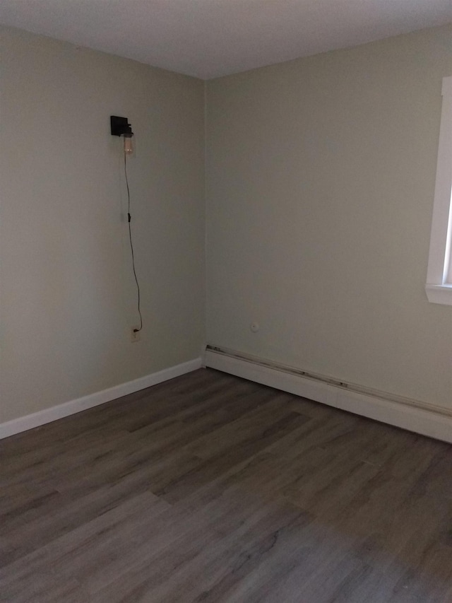 empty room with baseboards, baseboard heating, and dark wood-style flooring